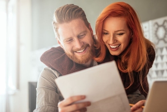 happy couple looking at paperwork