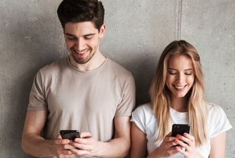 man and woman checking investments on phone