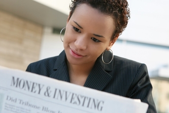 woman reading investment section of newspaper