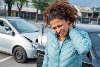 Woman suffering whiplash after bad cars pile up