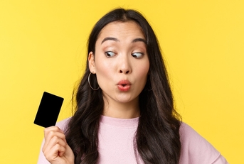 girl looking amused at credit card