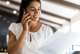 Woman on phone reading paperwork