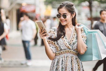 Woman carrying shopping bags and looking at her phone