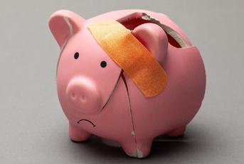 Broken piggy bank with band-aid