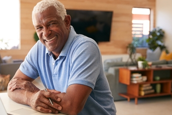 Man working on bills and smiling