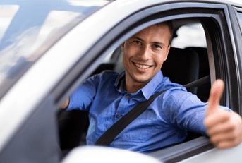 happy man giving thumbs up in car