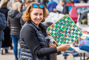 Smiling woman holding up board game