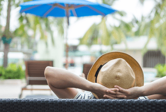 Person relaxing by hotel pool 