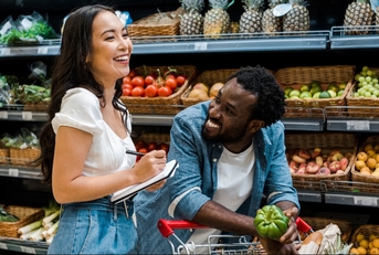 happy african american man looking at asian woman with notebook 