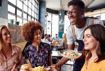 waiter serving group of female friends