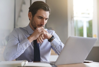 businessman concentrating on laptop in modern office