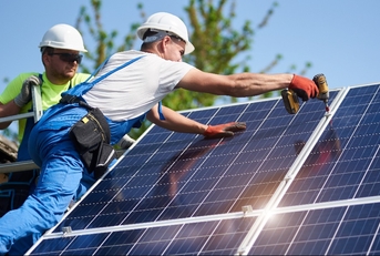 technicians installing heavy solar photo voltaic panels to high steel platform
