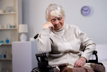depressed aged lady in wheelchair thinking about health problems at hospital