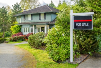 house for sale real estate sign in front of a house