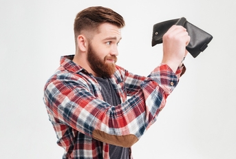 young man in plaid shirt looking inside his empty wallet