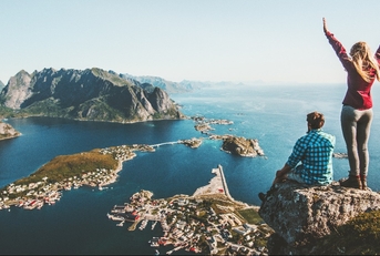couple family traveling together on cliff edge in Norway