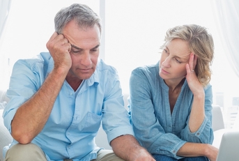 worried couple using their laptop to pay their bills