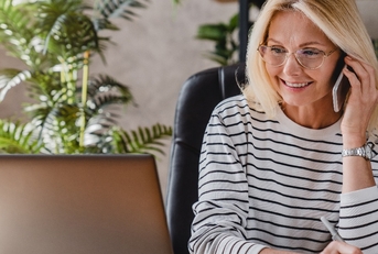 beautiful elderly businesswoman speaking on smart phone while working