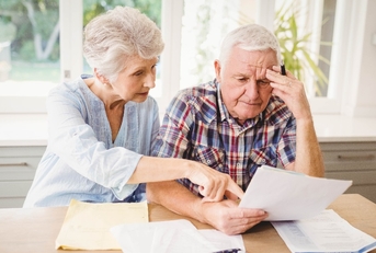 Worried senior couple checking their bills