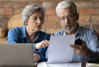 serious mature couple checking financial documents
