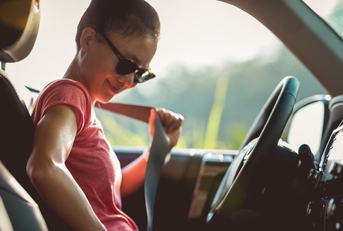 Woman driver buckle up the seat belt before driving car