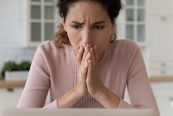Shocked hispanic female read unexpected bad news on pc
