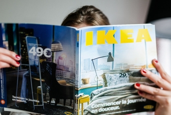 Woman reading IKEA magazine in living room