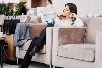 Woman reading book in hotel lounge