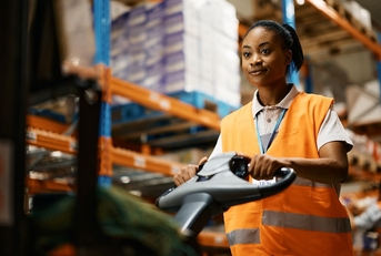 female worker pushing cargo on pallet jack