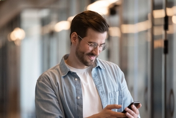 Happy young businessman using smartphone