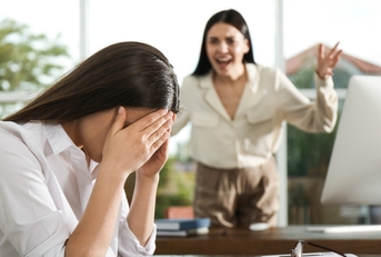 boss screaming at employee in office