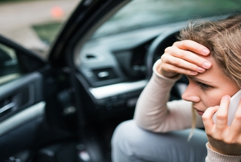 Woman worried in the car making a phone call