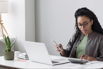 woman accountant using calculator and computer in office 