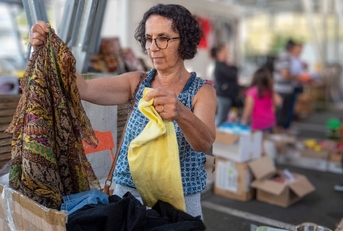 woman choosing clothes at garage sale