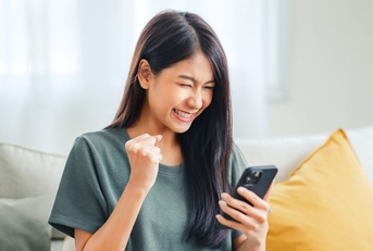happy Asian woman looking at phone