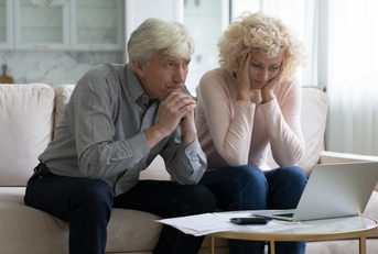 mature husband and wife frustrated about overspending family budget 