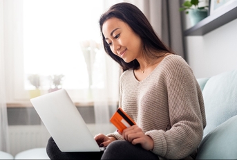 asian woman making online payment using laptop for shopping at home