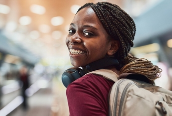 a woman in an airport looking back and smiling