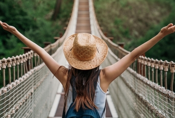 Happy woman traveler on a bridge
