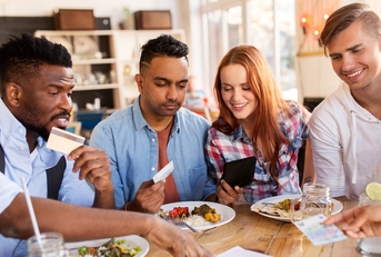 happy friends with money paying bill at restaurant