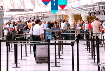 Travelers waiting in an airport security line. 