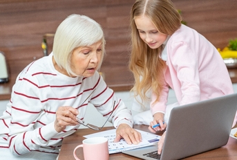 female grandchild and her granddaughter looking at the calendar