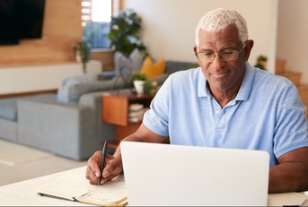 man using laptop to check finances at home