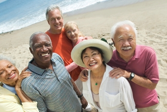 group of happy senior couples on beach