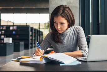 female student studying at college library