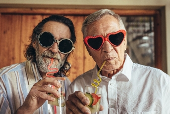 retired men wearing funny sunglasses drinking juice