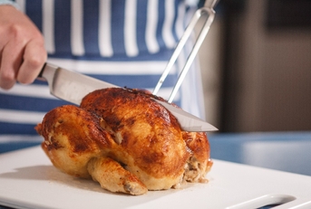 slicing chicken on cutting board