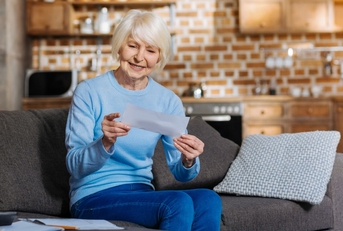 Senior woman smiling and holding a check