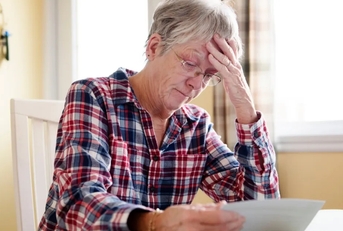 stressing senior lady reading document