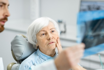 worried elder woman during the consultation with the dentist